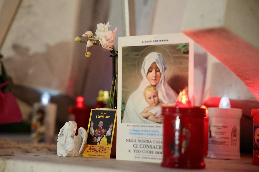 An image of Pope Leo XIV and other items are displayed outside Rome's Gemelli Hospital in the evening hours of Oct. 13, 2026, where the pontiff underwent surgery to remove a lung nodule. The Vatican announced that evening the surgery was successful. (OSV News photo/Stoyan Nenov, Reuters)