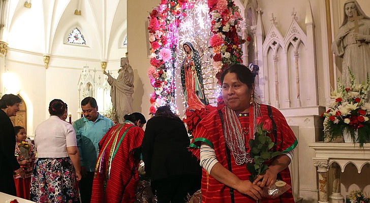 The Shrine Church of Our Lady of the Americas in Albany celebrated a Mass honoring Our Lady of Guadalupe with Bishop Edward B. Scharfenberger on Sunday, Dec. 15. According to CNS, “Our Lady of Guadalupe appeared to St. Juan Diego on Tepeyac Hill near Mexico City on Dec. 9 and Dec. 12, 1531, saying she wanted a church built in her honor on that hill. The bishop, who originally ignored Juan Diego, asked for a sign from her and Mary produced enough roses in December to fill his tilma, a type of outer garment. When he emptied the cloak and the roses fell in front of the bishop, he found that she had left her image on the cloak, which remains today in the Basilica of Our Lady of Guadalupe in Mexico City.” The feast day of Our Lady of Guadalupe is Dec. 12.   Eduarda Lopez pauses after placing flowers at the base of the statue of Our Lady of Guadalupe.  Photos by Thomas Killips