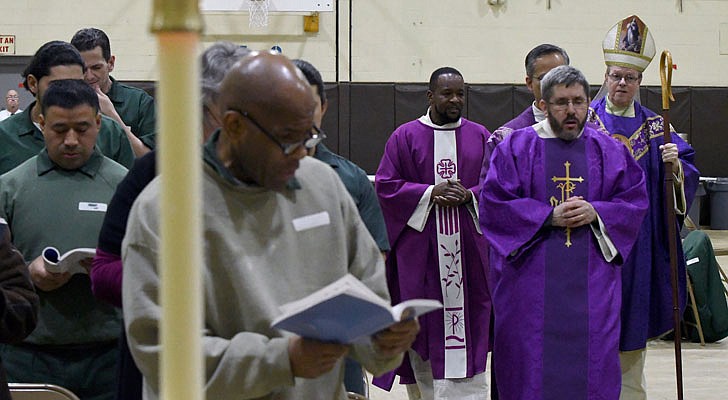 Bishop Edward B. Scharfenberger celebrated a special Christmas Mass for inmates at the Washington Correctional Facility in Comstock on Thursday, Dec. 19. Deacon Miguel Fabian, the facility’s chaplain, Father Rendell Torres and Deacon Ryan McNulty resided over the Mass, which was held in the facility’s gymnasium and attended by 33 inmates.  Deacon Ryan McNulty leads the procession.  Michael P. Farrell photos