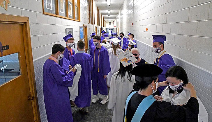 Catholic Central High School in Troy held its 97th Commencement Exercises on Saturday, July 25, under a tent at the athletic fields. The school graduated 40 seniors, including Valedictorian Paul Barber and Salutatorian Michael J. Paglia. Bishop Edward B. Scharfenberger presided and blessed the graduates.  Counselor Aileen Ryan, r., adjusts Hana Rule's gown and sash.  Photos by Michael P. Farrell 