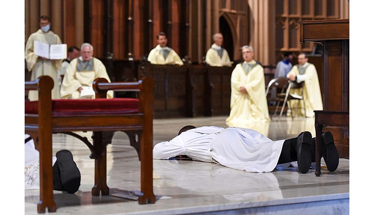 The combined Priesthood Ordination Rite and Diaconate Ordination Rite was celebrated by Bishop Edward B. Scharfenberger, with one man ordained to the priesthood and 13 men ordained to the Diaconate - eight men to the Permanent Diaconate and five men to the Transitional Diaconate - on Sept. 5 at the Cathedral of the Immaculate Conception in Albany.   Deacon Charles Onyeneke lies prone as part of his Rite of Ordination to the Priesthood.  Photos by Cindy Schultz 