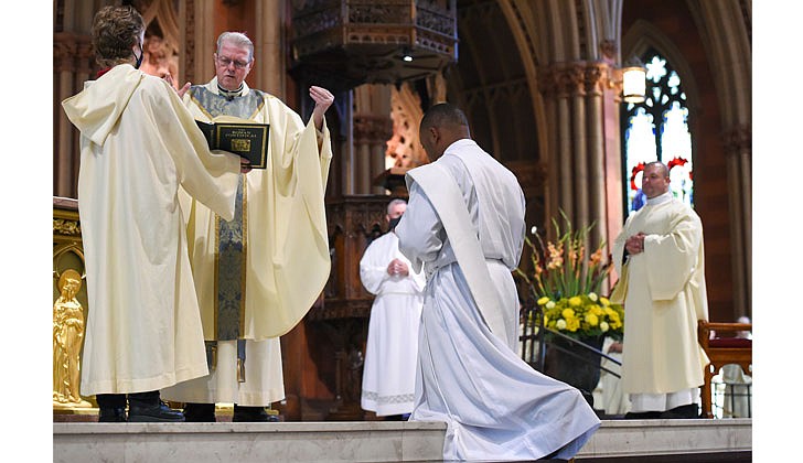 The combined Priesthood Ordination Rite and Diaconate Ordination Rite was celebrated by Bishop Edward B. Scharfenberger, with one man ordained to the priesthood and 13 men ordained to the Diaconate - eight men to the Permanent Diaconate and five men to the Transitional Diaconate - on Sept. 5 at the Cathedral of the Immaculate Conception in Albany.   Bishop Scharfenberger reads the Prayer of Ordination, the final step for Deacon Charles Onyeneke to become a newly-ordained priest.  Photos by Cindy Schultz 