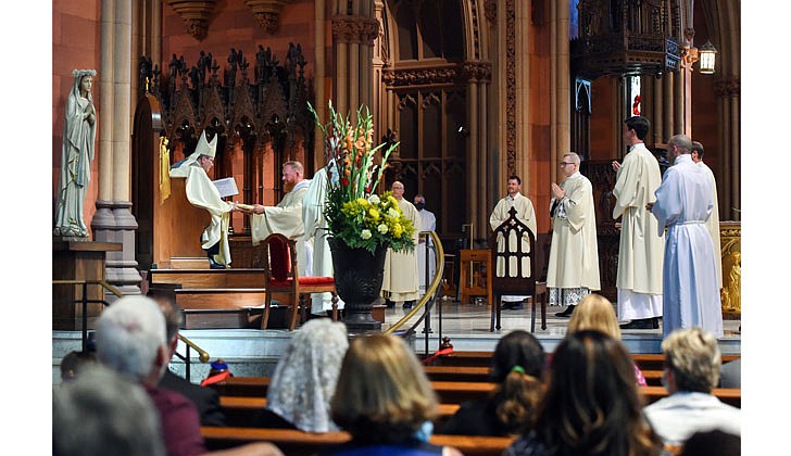 The combined Priesthood Ordination Rite and Diaconate Ordination Rite was celebrated by Bishop Edward B. Scharfenberger, with one man ordained to the priesthood and 13 men ordained to the Diaconate - eight men to the Permanent Diaconate and five men to the Transitional Diaconate - on Sept. 5 at the Cathedral of the Immaculate Conception in Albany.   Bishop Scharfenberger presents each of the newly-ordained deacons with the Book of the Gospels.  Photos by Cindy Schultz 