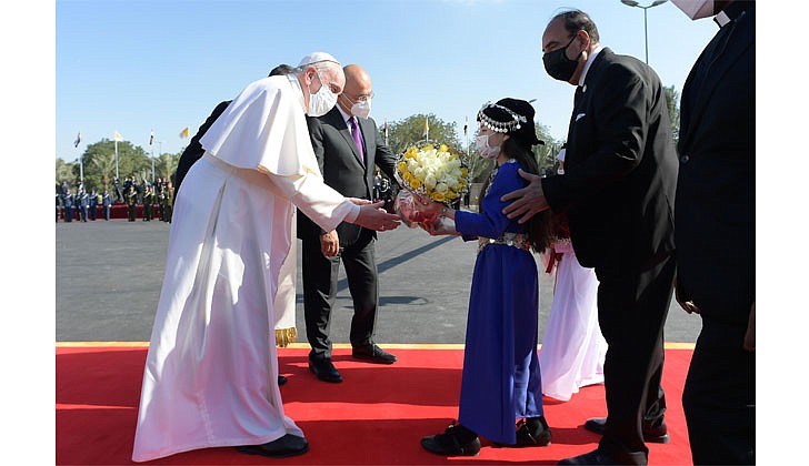 Pope Francis arrived in Baghdad, Iraq on Friday for his historic four-day visit to the Middle East nation. It is the first time a pope has ever visited Iraq and Pope Francis’ first foreign trip in 15 months because of the COVID-19 pandemic. The visit was to promote peace, tolerance and equality in the troubled nation.   Caption: Pope Francis receives flowers from children during a welcoming ceremony with Iraqi President Barham Salih at the presidential palace in Baghdad on March 5. (CNS photo/Vatican Media)