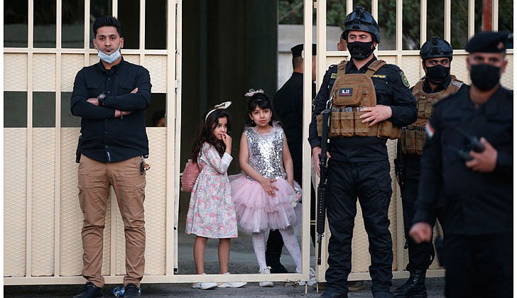 Pope Francis arrived in Baghdad, Iraq on Friday for his historic four-day visit to the Middle East nation. It is the first time a pope has ever visited Iraq and Pope Francis’ first foreign trip in 15 months because of the COVID-19 pandemic. The visit was to promote peace, tolerance and equality in the troubled nation.   Caption: Young girls watch near security personnel after Pope Francis' meeting with bishops, priests, religious men and women, seminarians and catechists in the Syriac Catholic Cathedral of Our Lady of Deliverance in Baghdad on March 5. (CNS photo/Paul Haring)