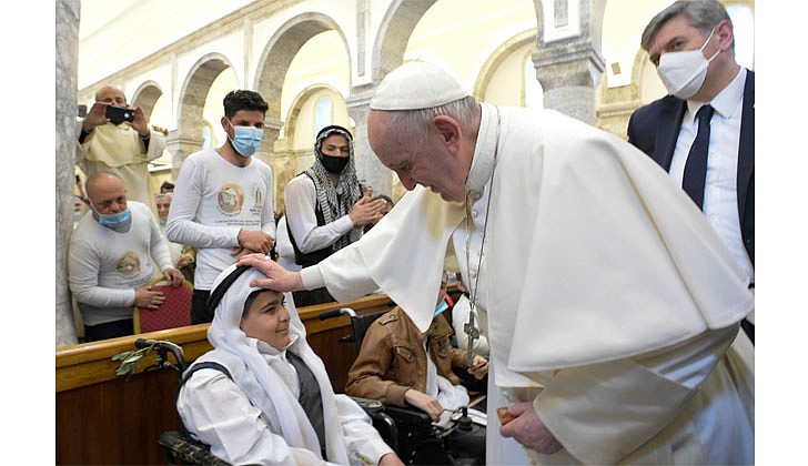 Pope Francis blesses a child as he greets people with disabilities during a visit to the Church of the Immaculate Conception in Qaraqosh, Iraq, March 7, 2021. (CNS photo/Vatican Media via Reuters)