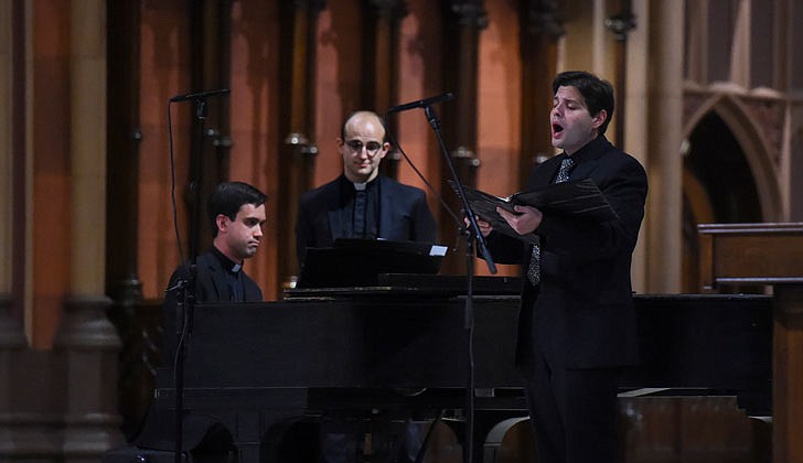 The Diocese of Albany held its seventh annual Concert for Vocations at the Cathedral of the Immaculate Conception in Albany on Aug. 3. Following Holy Hour and Benediction, Bishop Edward B. Scharfenberger, along with priests, deacons, religious discerners and laity, performed during the concert which mixed classic and contemporary music. Bishop Scharfenberger performed “The Impossible Dream” from Man of La Mancha as well as "Fratello Sole, Sorella Luna" (Brother Sun, Sister Moon). To watch the concert, head to rcda.org.  Caption: Alexander Turpin sings and Father Matthew Duclos (l.) accompanies him on the piano while Father Samuel Bellafiore turns the pages during the Concert for Vocations   Photos by Cindy Schultz 