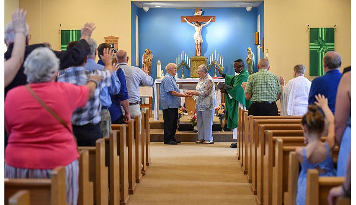 Parishioners join Father Simon Udemgba in blessing Ray Germain and Joanne McKeon as they renew their vows on their fifth wedding anniversary on July 11  at St. Joseph’s Church in Greenfield Center. (Cindy Schultz for The Evangelist)