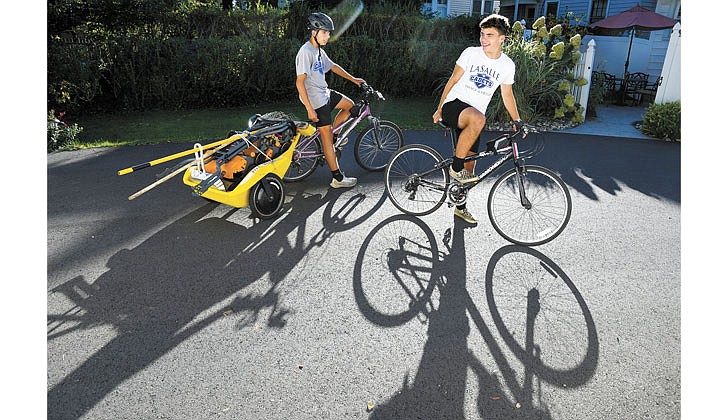 With their equipment packed up, twin brothers Patrick (l.) and Brendan McNaughton, 16, prepare to pedal to the next customer’s home on Sept. 19 in Albany. The brothers operate an environmentally-friendly lawn service business together called Zero Carbon Lawn Care. (Cindy Schultz for The Evangelist)