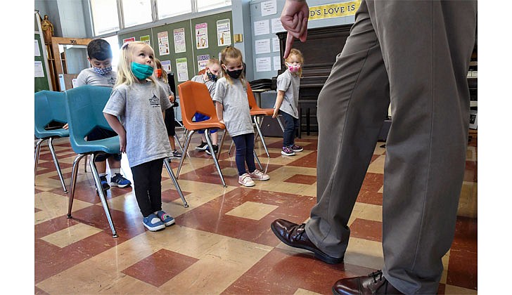 Three-year-olds learn the movements to “If You’re Happy and You Know It” as music teacher Eugene Lorini demonstrates how to tap a foot on Sept. 16 at St. Mary’s School in Waterford. (Cindy Schultz for The Evangelist)