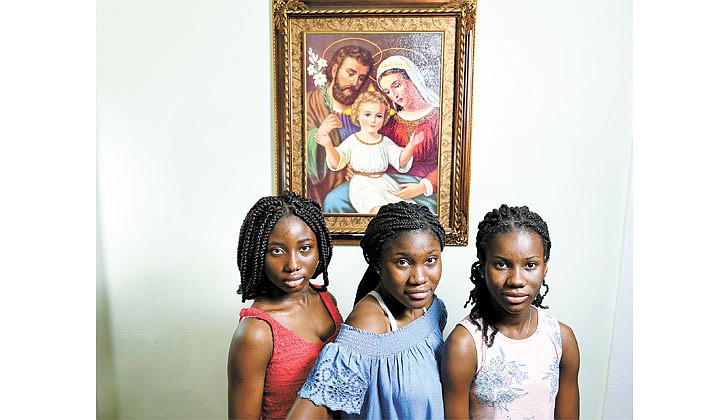 The Niangoran sisters: Naomi, 17, (from l), Sephora, 16, and Melissa, 12, are shown at their home on April 14 in Troy. The sisters, who are from the Ivory Coast, were baptized at Our Lady of Victory Church during Easter Vigil. (Cindy Schultz for The Evangelist)