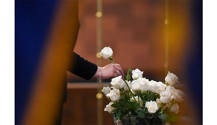 A family member of a fallen police officer places a white rose in a vase to signify the sacrifice made during the Blue Mass on Sept. 29 at the Cathedral of the Immaculate Conception in Albany. The annual memorial Mass honors the deceased members of the law enforcement community. (Cindy Schultz for The Evangelist)