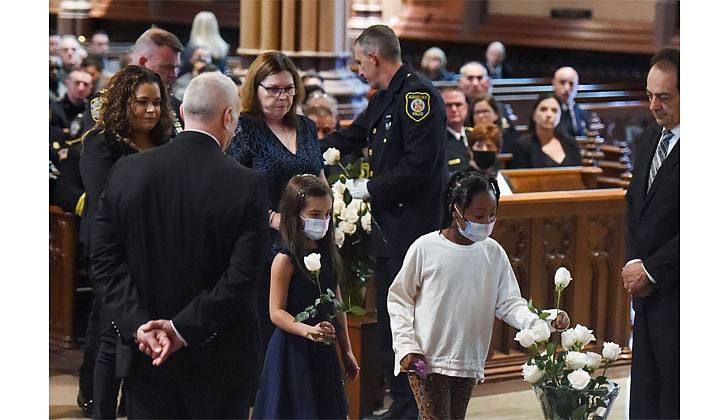 Family members of fallen police officers place white roses in a vase to signify the sacrifices they made during the Blue Mass on Sept. 29 at the Cathedral of the Immaculate Conception in Albany. The annual memorial Mass honors the deceased members of the law enforcement community. (Cindy Schultz for The Evangelist)