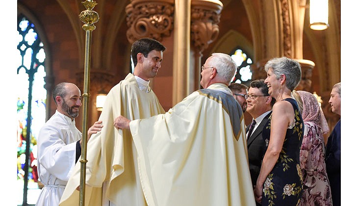 Newly-ordained priest Matthew Duclos (c.) is vested with stole and chasuble during the Rite of Ordination on June 19 at the Cathedral of the Immaculate Conception in Albany. (Cindy Schultz for The Evangelist)