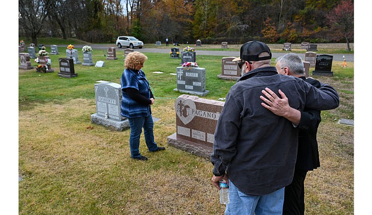 Father Desmond Rossi (r.) supports Vince Pagano and his wife, Christina Pagano, at the gravesite of their eldest son, Vince Pagano, Jr., on Nov. 9, at St. Adalbert Cemetery in Rotterdam. Vince Jr., died in 2004, Father Rossi received one of his kidneys and finally met Vince Sr., and Christina after 17 years. (Cindy Schultz for The Evangelist)