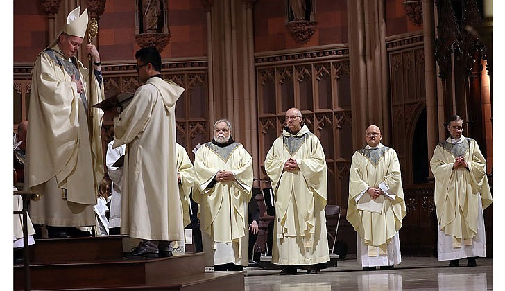 Bishop Edward B. Scharfenberger presided at the Chrism Mass at the Cathedral of the Immaculate Conception in Albany on April 7. Bishop Scharfenberger blessed three oils: the oil of catechumens, the oil of the sick and holy chrism, which will be used in the administration of the sacraments in parishes throughout the Diocese of Albany in the coming year. In addition, the faithful in the Cathedral renewed their baptismal promises, and priests and deacons renewed their ordination promises.  Bishop Scharfenberger renews the commitment of service to the baptized during the Chrism Mass. The Episcopal Vicars are being renewed in this photo.  Photos by Thomas Killips