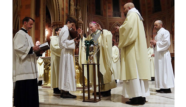 Bishop Edward B. Scharfenberger presided at the Chrism Mass at the Cathedral of the Immaculate Conception in Albany on April 7. Bishop Scharfenberger blessed three oils: the oil of catechumens, the oil of the sick and holy chrism, which will be used in the administration of the sacraments in parishes throughout the Diocese of Albany in the coming year. In addition, the faithful in the Cathedral renewed their baptismal promises, and priests and deacons renewed their ordination promises.  Bishop Scharfenberger blesses the oil of the catechumens.  Photo by Thomas Killips 