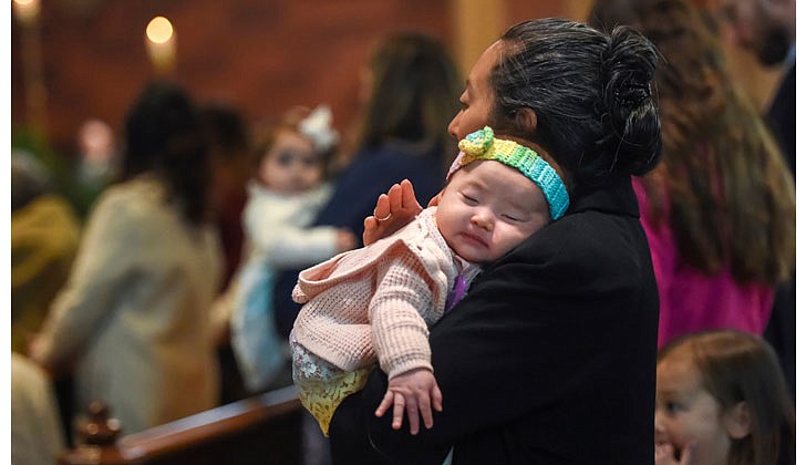 Bishop Edward B. Scharfenberger celebrated Easter Sunday Mass at the Cathedral of the Immaculate Conception in Albay on April 17. Here is a pictorial look back!  Caption: Two-month old Magdalena Lynch naps in the arms of her mother, Lisa Lynch, during Easter Mass.   Photos by Cindy Schultz