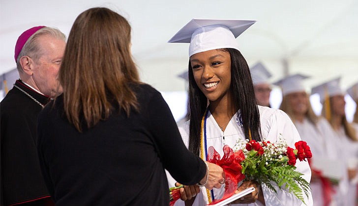 The Academy of the Holy Names celebrated its 133rd commencement ceremony on May 27 with Bishop Edward B. Scharfenberger presiding. 100 percent of the 44 graduating seniors were accepted into colleges and universities which included Cornell, Dartmouth, Fordham, Holy Cross, Villanova and Notre Dame. They also received a total $18.4 million in merit-based scholarships. Over the last four years, the seniors also performed 2,485 hours of community service.  Graduate Atarah Bryant receives her diploma and red roses.  Patrick Dodson photos for The Evangelist