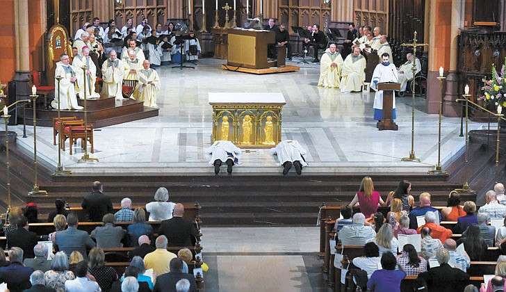 Calling the priesthood “a ministry of love,” Bishop Edward B. Scharfenberger of the Diocese of Albany presided over the Ordination to the Priesthood of Father Russell Bergman and Father James O’Rourke - who were both profiled in last week’s The Evangelist - on June 18 at the Cathedral of the Immaculate Conception in Albany.  Father O’Rourke celebrated his first Mass at Blessed Sacrament in Albany on June 19, while Father Bergman celebrated his first Mass at Our Lady of Victory in Troy.  Father Bergman said of his ordination: “It was beyond comparison to any experience I’ve had in my life. An awesome experience in the true divine sense of awesome, full of humility, joy, wonder, intensity, thanksgiving, fulfillment and palpable love, among so many other feelings that words alone cannot capture.”   The parish assignments for both priests are expected to be announced on June 27.  Candidates for the priesthood, Deacons Russell Bergman (l.) and James O’Rourke, lie prone for the Litany of Supplication.  Cindy Schultz photos for The Evangelist. 