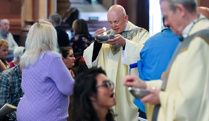 Calling the priesthood “a ministry of love,” Bishop Edward B. Scharfenberger of the Diocese of Albany presided over the Ordination to the Priesthood of Father Russell Bergman and Father James O’Rourke - who were both profiled in last week’s The Evangelist - on June 18 at the Cathedral of the Immaculate Conception in Albany.  Father O’Rourke celebrated his first Mass at Blessed Sacrament in Albany on June 19, while Father Bergman celebrated his first Mass at Our Lady of Victory in Troy.  Father Bergman said of his ordination: “It was beyond comparison to any experience I’ve had in my life. An awesome experience in the true divine sense of awesome, full of humility, joy, wonder, intensity, thanksgiving, fulfillment and palpable love, among so many other feelings that words alone cannot capture.”   The parish assignments for both priests are expected to be announced on June 27.  Newly ordained priest, Father Russell Bergman, hands out Communion to the faithful.  Cindy Schultz photos for The Evangelist.  