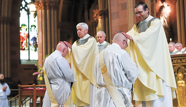 Calling the priesthood “a ministry of love,” Bishop Edward B. Scharfenberger of the Diocese of Albany presided over the Ordination to the Priesthood of Father Russell Bergman and Father James O’Rourke - who were both profiled in last week’s The Evangelist - on June 18 at the Cathedral of the Immaculate Conception in Albany.  Father O’Rourke celebrated his first Mass at Blessed Sacrament in Albany on June 19, while Father Bergman celebrated his first Mass at Our Lady of Victory in Troy.  Father Bergman said of his ordination: “It was beyond comparison to any experience I’ve had in my life. An awesome experience in the true divine sense of awesome, full of humility, joy, wonder, intensity, thanksgiving, fulfillment and palpable love, among so many other feelings that words alone cannot capture.”   The parish assignments for both priests are expected to be announced on June 27.  Candidates for the priesthood, Deacons Russell Bergman (l.) and James O’Rourke, receive the "Laying on of Hands and Prayer of Ordination" from diocesan priests.  Cindy Schultz photos for The Evangelist.