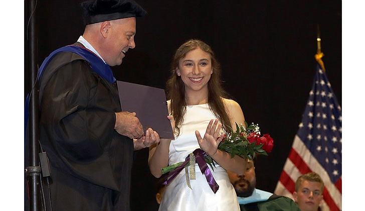 Catholic Central High School held its 99th Commencement Ceremony at Hudson Valley Community College on June 25. The graduating class of 46 seniors received $6.5 million in college scholarships, grants and aid. Catholic High will merge with St. Ambrose School in Latham to form Catholic Central School, a pre-K through Grade 12 regional Catholic school, in Latham. The doors to the new school open in September.  Isadora Lee, valedictorian, waves to Lou Rosamilia as she accepts the Stephanie Rosamailia Memorial Scholarship presented by CCHS Principal Christopher Signor.  Photos by Thomas Killips