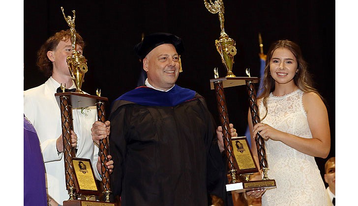 Catholic Central High School held its 99th Commencement Ceremony at Hudson Valley Community College on June 25. The graduating class of 46 seniors received $6.5 million in college scholarships, grants and aid. Catholic High will merge with St. Ambrose School in Latham to form Catholic Central School, a pre-K through Grade 12 regional Catholic school, in Latham. The doors to the new school open in September.  CCHS Principal Christopher Signor presents the Crusader of the Year trophies to Gabriel Lammon (partially hidden) and Madeline Finn.   Photos by Thomas Killips