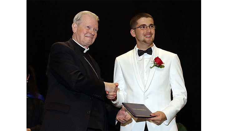 Catholic Central High School held its 99th Commencement Ceremony at Hudson Valley Community College on June 25. The graduating class of 46 seniors received $6.5 million in college scholarships, grants and aid. Catholic High will merge with St. Ambrose School in Latham to form Catholic Central School, a pre-K through Grade 12 regional Catholic school, in Latham. The doors to the new school open in September.  Bishop Edward B. Scharfenberger presents Samuel Carusone with his diploma.  Photos by Thomas Killips