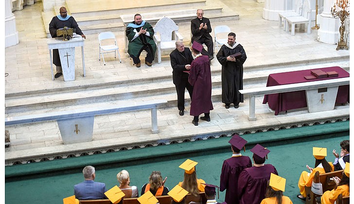 Notre Dame-Bishop Gibbons School held its Commencement Ceremony on June 25 at St. John the Evangelist Church in Schenectady. With a 100 percent graduation rate, the 33 seniors received over $8 million dollars in scholarships and grants for college over four years. In addition, they were accepted into 65 colleges and universities in 12 states and 20 New York counties.   Bishop Edward B. Scharfenberger (c.) congratulates NDBG graduate Lincoln Hempstead during the conferring of diplomas.  Cindy Schultz photos for The Evangelist