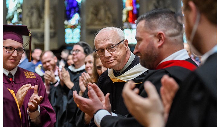 Notre Dame-Bishop Gibbons School held its Commencement Ceremony on June 25 at St. John the Evangelist Church in Schenectady. With a 100 percent graduation rate, the 33 seniors received over $8 million dollars in scholarships and grants for college over four years. In addition, they were accepted into 65 colleges and universities in 12 states and 20 New York counties.   Retiring teacher Tom Hartnett (c.) receives a standing ovation from staff, graduates and their families. Hartnett is retiring from a 50-year teaching career.  Cindy Schultz photos for The Evangelist