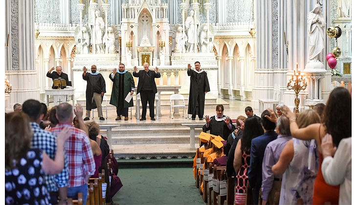 Notre Dame-Bishop Gibbons School held its Commencement Ceremony on June 25 at St. John the Evangelist Church in Schenectady. With a 100 percent graduation rate, the 33 seniors received over $8 million dollars in scholarships and grants for college over four years. In addition, they were accepted into 65 colleges and universities in 12 states and 20 New York counties.   Father Leo Markert, chaplain (l.) leads a blessing for the graduates at the conclusion of Notre Dame-Bishop Gibbons commencement exercises.  Cindy Schultz photos for The Evangelist