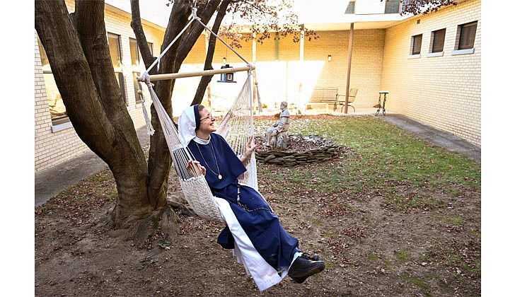 Sister Monica Marie takes a swing in a rope chair in the courtyard on Jan. 15 in Catskill.  Cindy Schultz photo for The Evangelist