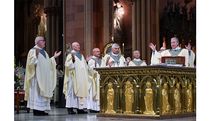 Newly ordained priests James O’Rourke (from l.) and Russell Bergman join fellow priests and Bishop Edward B. Scharfenberger at the altar for the Liturgy of the Eucharist during the Priesthood Ordination on June 18 at the Cathedral of the Immaculate Conception in Albany.    Cindy Schultz photo for The Evangelist