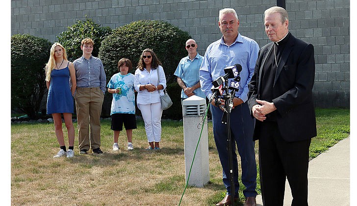 Bishop Edward B. Scharfenberger steps to the microphone as clergy abuse survivor Stephen Mittler and his family watch during their historic meeting on July 31.  Thomas Killips photo
