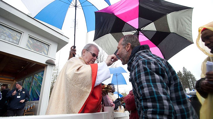 Thousands braved the rain and cold temperatures to attend Mass on Divine Mercy Sunday at the National Shrine of Divine Mercy in Stockbridge, Mass., on Sunday, April 28. Bishop Edward Scharfenberger celebrated the Mass, blesses the crowd with the heart of St. Jean Vianney, the patron saint of parish priests, and gives out communion along with other priests. Divine Mercy is based on St. Faustina Kowalska’s visions and conversations she had with Jesus Christ, who asked St. Faustina to paint the vision of Divine Mercy. Divine Mercy Sunday is the first Sunday after Easter. (Nate Whitchurch photos)