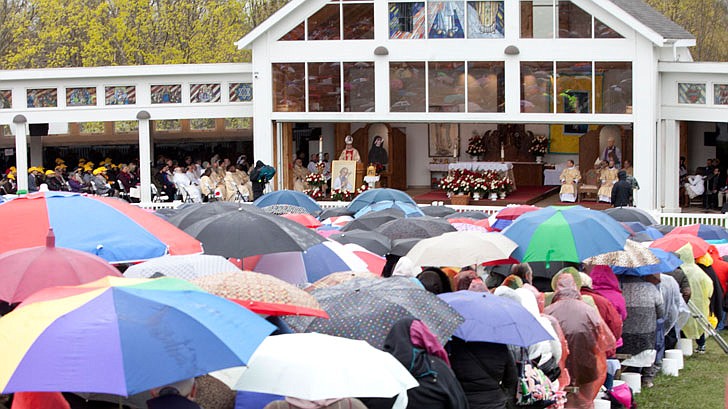 Thousands braved the rain and cold temperatures to attend Mass on Divine Mercy Sunday at the National Shrine of Divine Mercy in Stockbridge, Mass., on Sunday, April 28. Bishop Edward Scharfenberger celebrated the Mass, blesses the crowd with the heart of St. Jean Vianney, the patron saint of parish priests, and gives out communion along with other priests. Divine Mercy is based on St. Faustina Kowalska’s visions and conversations she had with Jesus Christ, who asked St. Faustina to paint the vision of Divine Mercy. Divine Mercy Sunday is the first Sunday after Easter. (Nate Whitchurch photos)