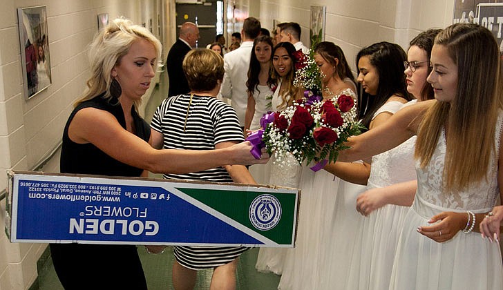 Catholic Central High School in Troy held its graduation on Saturday, June 8, at Hudson Valley Community College.   Guidance counselor Riley Long hands a bouquet of flowers to Samantha McNab before graduation begins.   Photos by Nate Whitchurch